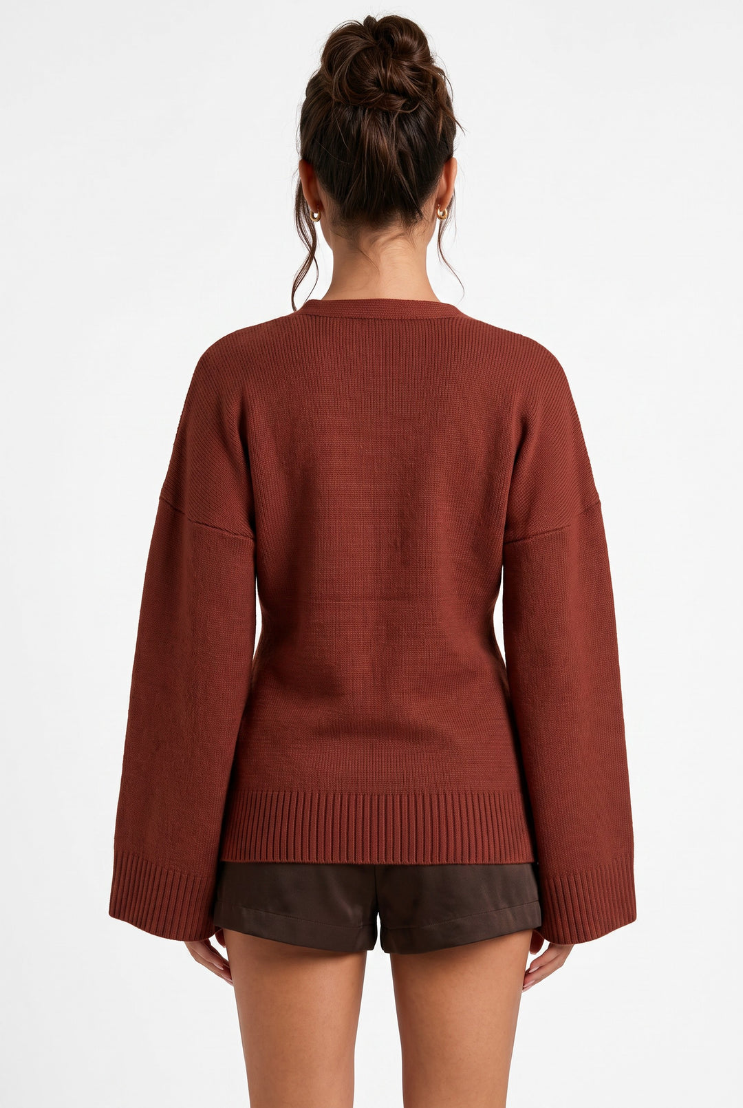 Back view of lily Averlyn brick red knit cardigan with wide sleeves and ribbed hem on a model