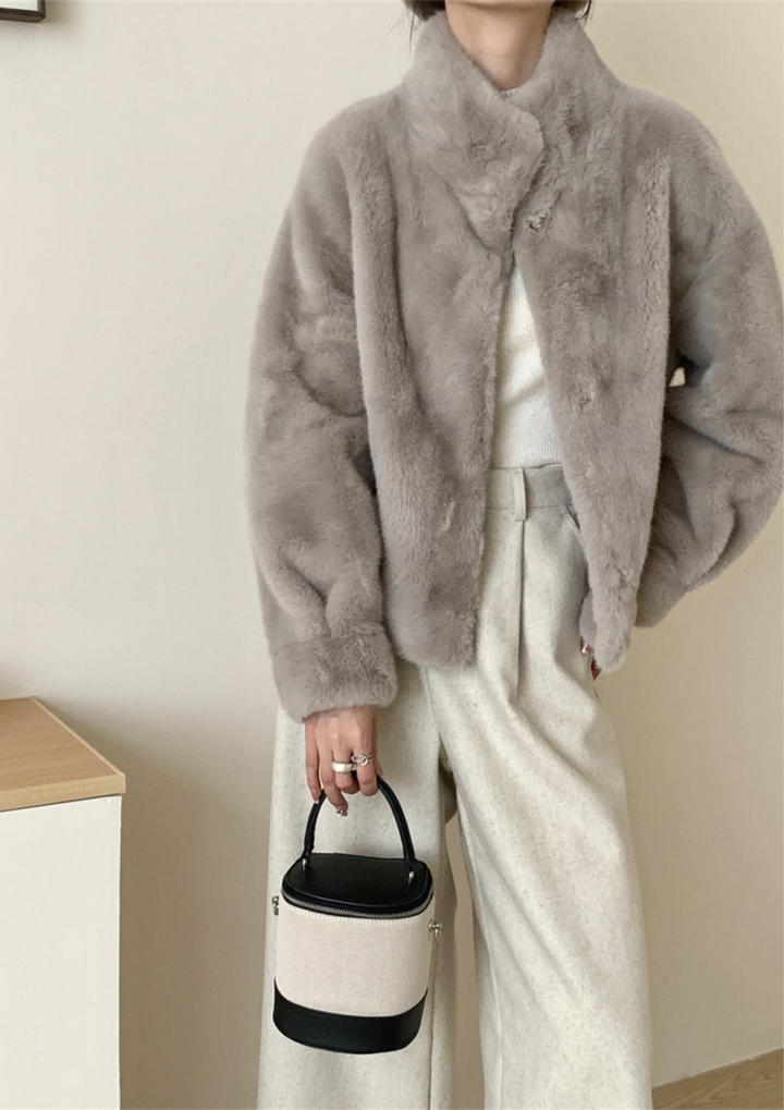 lily Mila plush mink fur coat in grey with a stand collar, worn over a white top and cream trousers