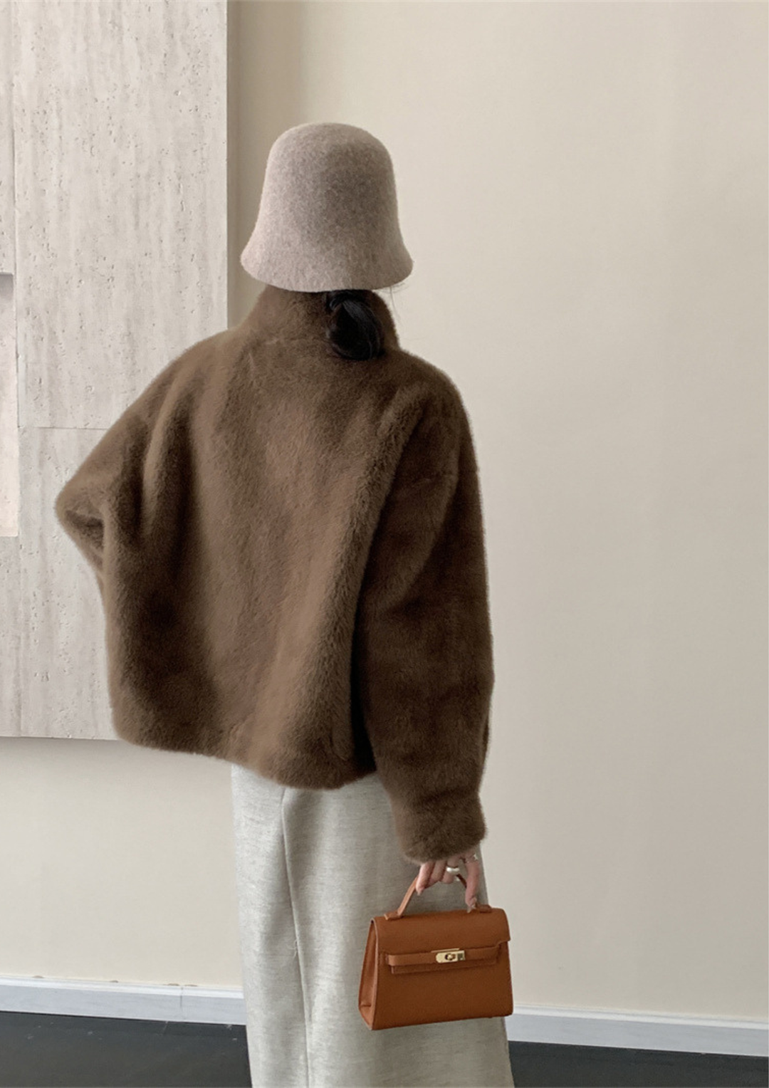 lily Mila plush brown mink fur coat worn with a beige bucket hat and a small brown leather handbag
